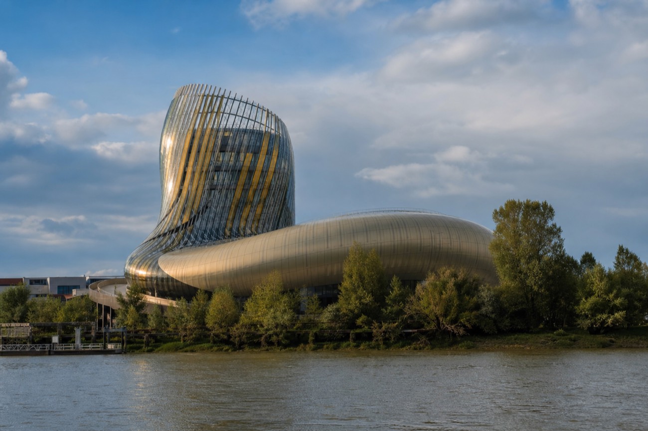 The curved modern facade of La Cité du Vin, Bordeaux's wine museum, on the riverbank